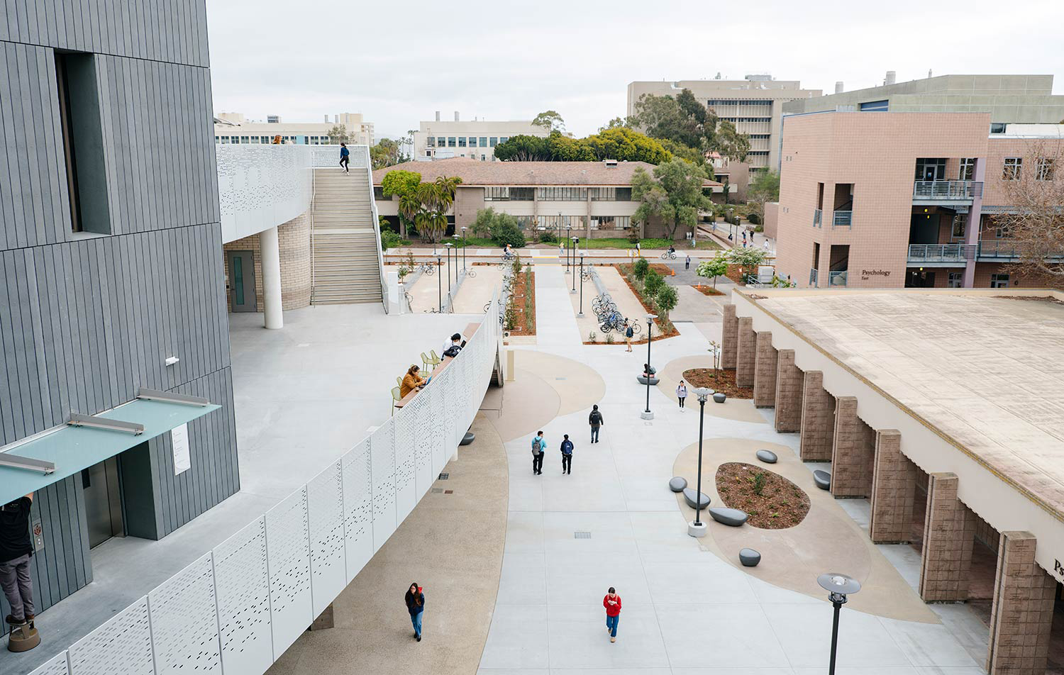 distance photo from high up in a building looking down on a few people walking on a sidewalk